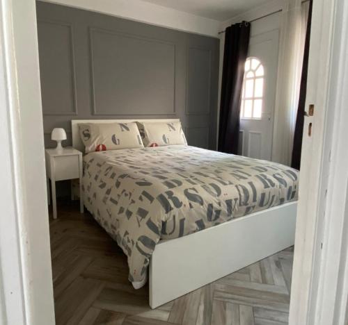 a bedroom with a white bed and a window at Appartement charmant et calme aux portes de Monaco in Cap d'Ail