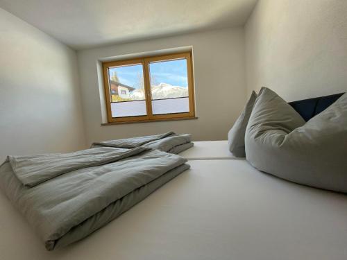 a bedroom with a bed and a window at Ferienwohnungen Moser in Steinberg am Rofan