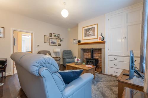 a living room with a blue couch and a fireplace at Sleeps 5 - 3 Bedrooms - walk to the square hosted Happy Valley cast in Hebden Bridge