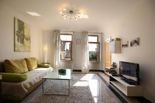 ein Wohnzimmer mit einem Sofa und einem TV in der Unterkunft Apartments Stadthaus Briski in Opatija