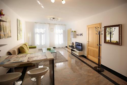 ein Wohnzimmer mit einem Sofa und einem Tisch in der Unterkunft Apartments Stadthaus Briski in Opatija