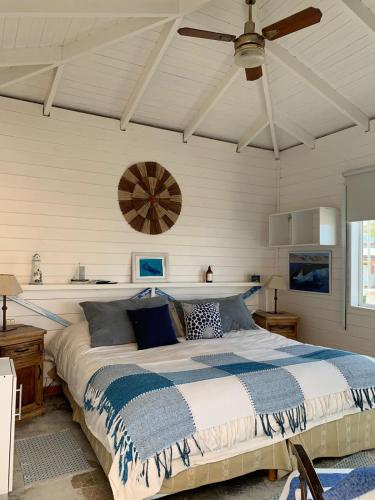 a bedroom with a bed and a ceiling fan at Hosteria Puerto Palos in Puerto Pirámides