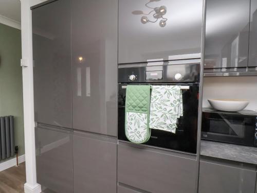 a kitchen with stainless steel appliances with towels on the oven at 22 Constable Road in Filey