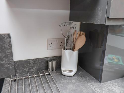 a kitchen with a utensil holder with utensils at 22 Constable Road in Filey