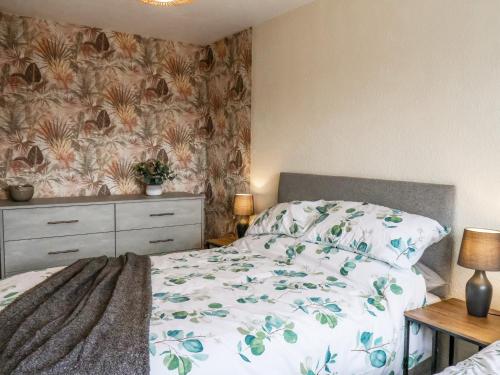 a bedroom with a bed and a floral wallpaper at 22 Constable Road in Filey
