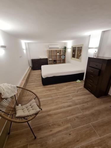 Cette chambre comprend un lit et une chaise. dans l'établissement Cohens apartments, à Jérusalem