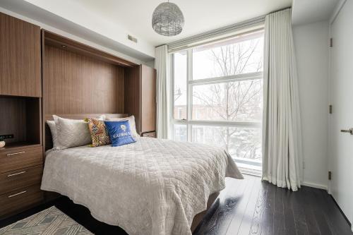 een slaapkamer met een bed en een groot raam bij GLOBALSTAY Exclusive 4 Bedroom Townhouse in Downtown Toronto with Parking in Toronto