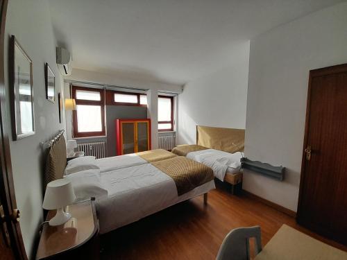 ein Hotelzimmer mit 2 Betten und einem Sofa in der Unterkunft Maison Giolitti in Turin