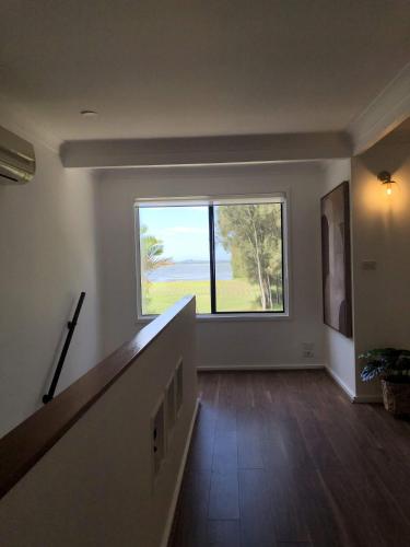 an empty hallway with a large window in a house at The COCO in The Entrance