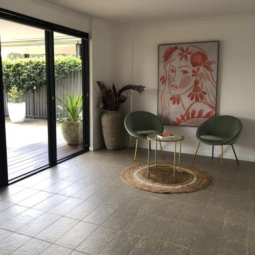 a living room with two chairs and a table at The COCO in The Entrance