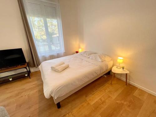 a bedroom with a bed with two lamps and a television at A1D Studio Nancy Thermal ARTEM in Nancy