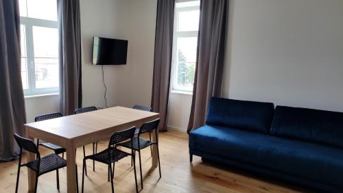 a living room with a table and a blue couch at Krems am Campus in Krems an der Donau