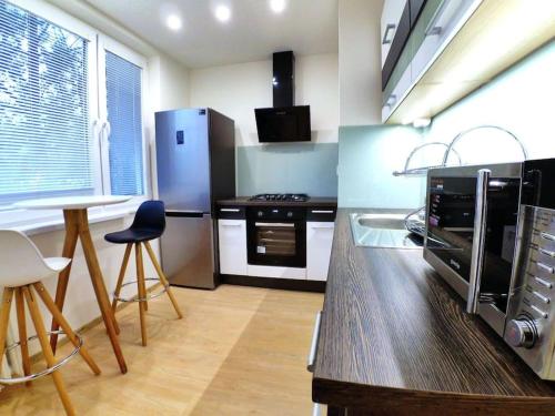 a kitchen with a refrigerator and a table and chairs at Komfort byt s parking zadarmo in Košice