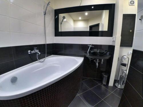 łazienka z dużą białą wanną i umywalką w obiekcie Komfort byt s parking zadarmo w Koszycach