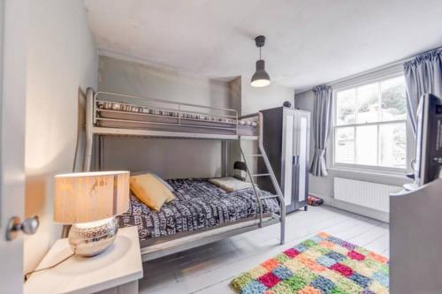 um quarto com um beliche e uma mesa com um candeeiro em Heart of the beautiful Old Town em Hastings