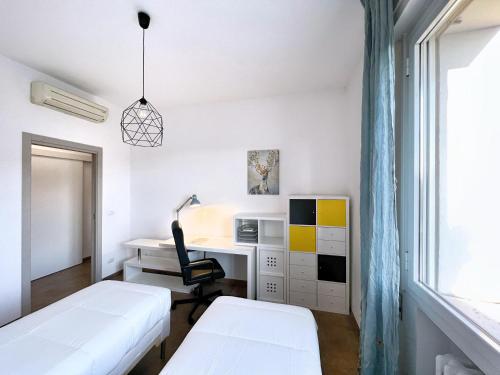 Cette chambre comprend deux lits, un bureau et une chaise. dans l'établissement UR NEST Filanda, à Bologne