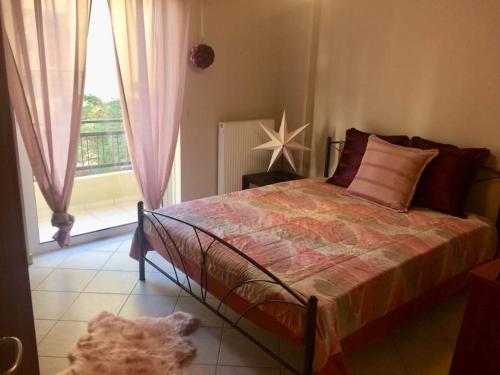 1 dormitorio con cama y ventana grande en Central Charming Apartment, en Tripolis