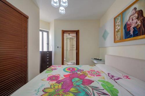 una camera da letto con un letto con copriletto floreale di Amazing 1 bedroom with views in Mellieha a Mellieħa