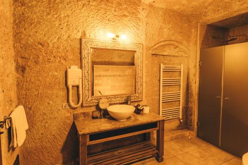ウルギュップにあるアルフィーナ ケーブ ホテルの石造りのバスルーム(シンク、鏡付)