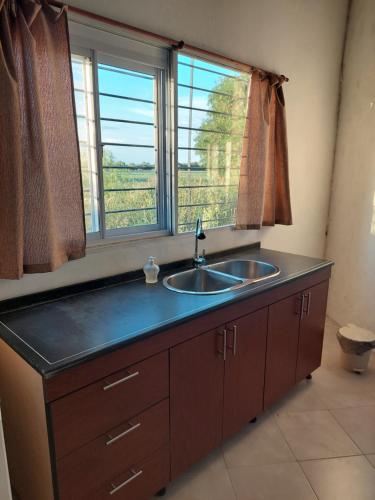 a kitchen with a sink and a window at Cabañas Apart del Sauce II in Paraná