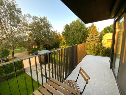 a balcony with a wooden bench and a fence at Kemény Klára Parti Háza in Zamárdi