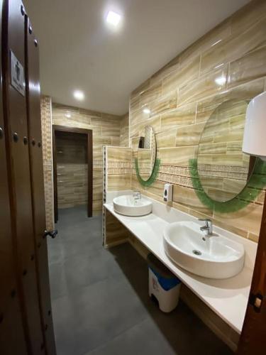 a bathroom with two sinks and a large mirror at LA CASONA in Siete Aguas