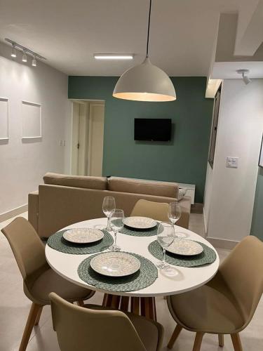 a dining room with a table and chairs with wine glasses at Lindo apartamento no Setor Bueno- todo reformado - tudo novinho -Sua busca termina aqui in Goiânia