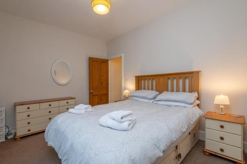a bedroom with a large bed with towels on it at Sleeps 5 - 3 Bedrooms - walk to the square hosted Happy Valley cast in Hebden Bridge