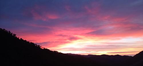 un tramonto tra le montagne con un cielo viola e rosso di Agriturismo Vecchio Frantoio a Villatella