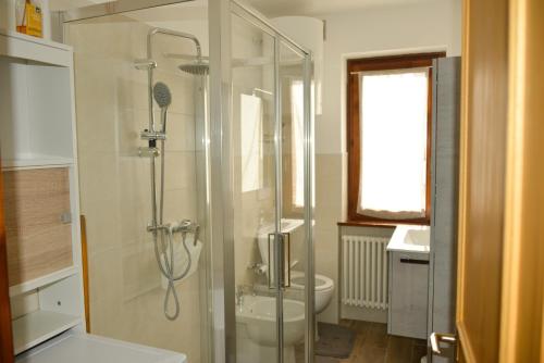 e bagno con doccia, servizi igienici e lavandino. di CASA GILDA Val di Fiemme - Dolomiti a Cavalese