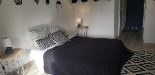 a bedroom with a bed with a black blanket on it at Bandol Studio in Bandol