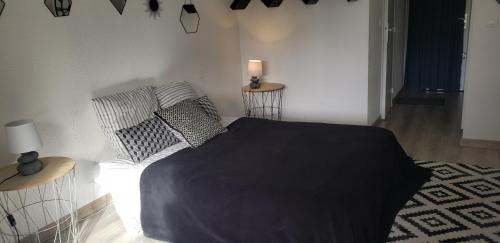 une chambre avec un lit avec une couverture noire dessus dans l'établissement Bandol Studio, à Bandol