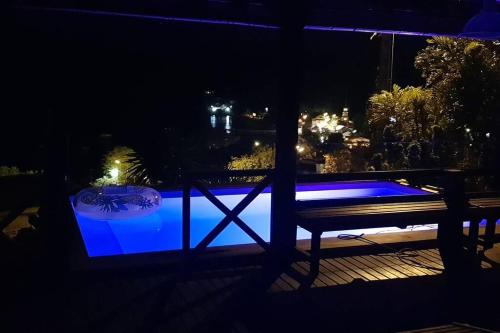 un banco sentado junto a una piscina por la noche en VILLA COCO ROSE, en Les Anses-dʼArlet