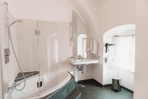 a bathroom with a bath tub and a sink at Schloss Gamlitz in Gamlitz