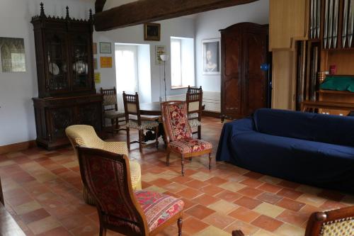 un salon avec un canapé bleu et des chaises dans l'établissement Chez Célestine, à Souvigny