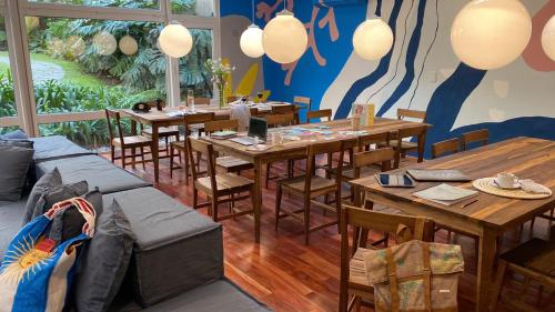 a restaurant with wooden tables and chairs and a large window at Casa Franca Recoleta Hostel in Buenos Aires