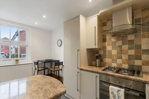a kitchen with white cabinets and a counter top at The Old Cooperage by Staytor Accommodation in Exeter