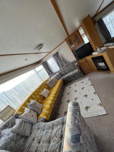 ein Schlafzimmer mit einem Bett und einem Sofa in einem Zimmer in der Unterkunft the Samanda Van Newport caravan park in Hemsby