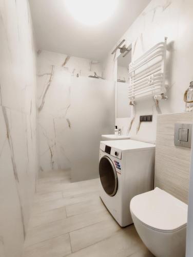 a bathroom with a washing machine and a toilet at Porto in Gdańsk