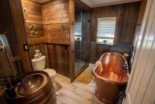 uma casa de banho com uma banheira de cobre e um chuveiro em Nebo's Foot, Cabin Escape with Game-Barn em Dardanelle