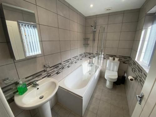 a bathroom with a sink and a tub and a toilet at Modern holiday home in Greetland