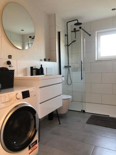 een badkamer met een wasmachine en een douche bij Modernes 2,5 Zimmer Apartment in Eppelborn, privater Eingang, eigener Parkplatz und Terrasse, Deine Ferienwohnung in Eppelborn mitten im Herzen des Saarlandes in Eppelborn