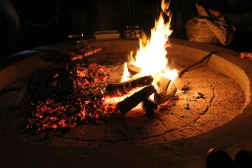 a fire pit with a person sitting next to it at Breede Bush Camp in Bakklysdrift