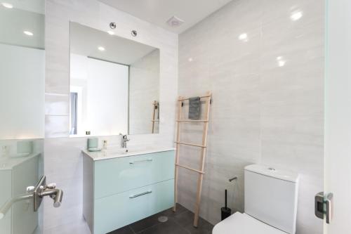a bathroom with a toilet and a sink and a mirror at Grand Beach House Bliss, By TimeCooler in Carcavelos