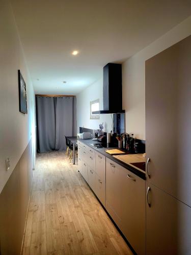 une cuisine avec des armoires blanches et une table à l'intérieur dans l'établissement Chambres d'hôte ROUQUART, à Méjannes-le-Clap