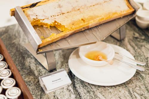 a table with a cake and a bowl of honey at Fairmont Windsor Park in Windsor