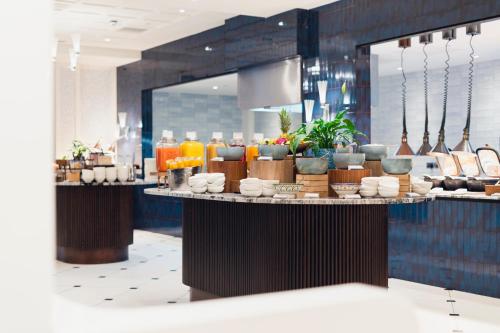 a restaurant with a counter with food and drinks at Fairmont Windsor Park in Windsor