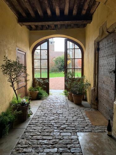 an entrance to a building with a stone walkway with potted plants at Maison Sainte Barbe in Autun