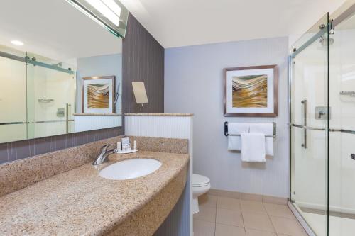 a bathroom with a sink and a shower and a toilet at Courtyard by Marriott Oklahoma City Downtown in Oklahoma City