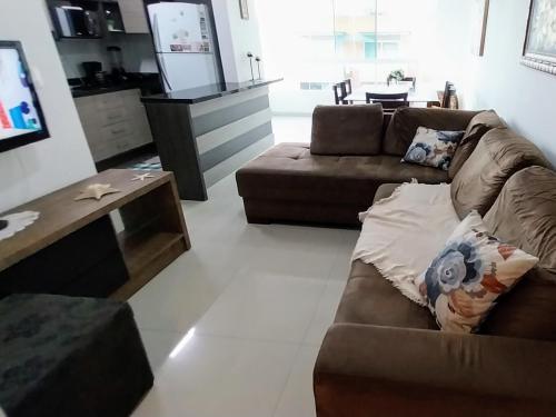 a living room with a couch and a coffee table at Espaçoso aconchegante in Capão da Canoa